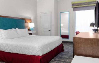 King bedroom with TV screen and window at the Hampton Inn Concord Bow.