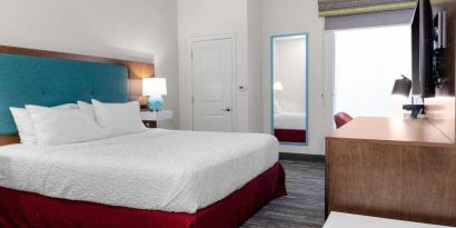 King bedroom with TV screen and window at the Hampton Inn Concord Bow.