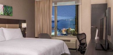 King bedroom with working station and city view at the Hilton Garden Inn Financial Center Manhattan Downtown, NY.