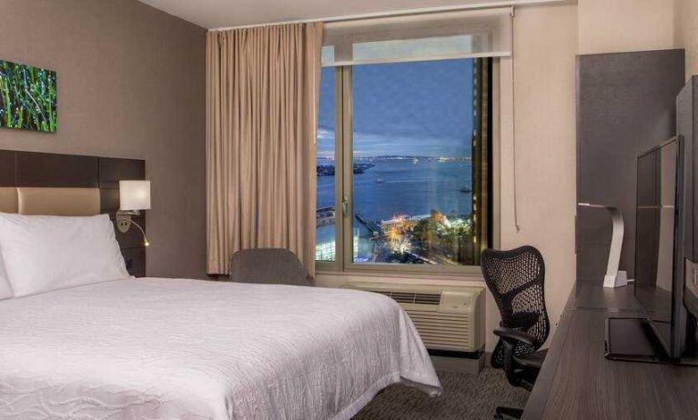 King bedroom with working station and city view at the Hilton Garden Inn Financial Center Manhattan Downtown, NY.