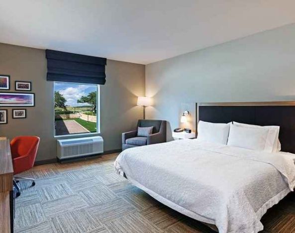 spacious king bedroom with work desk and natural light ideal for working remotely at Hampton Inn Bulverde Texas Hill Country.