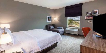 comfortable king room with TV, lounge area, and work desk ideal for working remotely at Hampton Inn Bulverde Texas Hill Country.