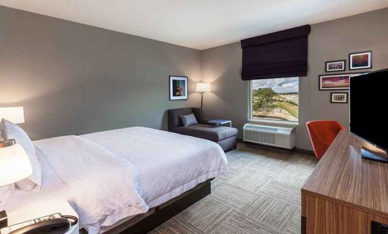 comfortable king room with TV, lounge area, and work desk ideal for working remotely at Hampton Inn Bulverde Texas Hill Country.