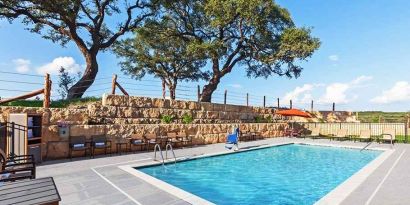 beautiful outdoor pool with comfortable seating area at Hampton Inn Bulverde Texas Hill Country.