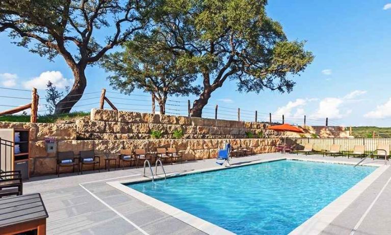 beautiful outdoor pool with comfortable seating area at Hampton Inn Bulverde Texas Hill Country.