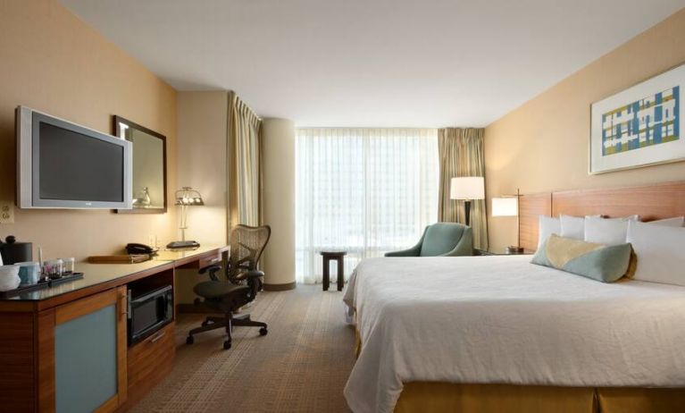 King guestroom with TV screen, desk and window at the Hilton Garden Inn Baltimore Inner Harbor.