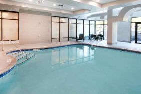 beautiful indoor pool with comfortable seating area at Embassy Suites by Hilton Seattle North Lynnwood.