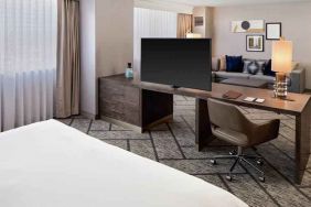 King suite with working station, TV screen and sofa at the DoubleTree by Hilton Tulsa-Downtown.