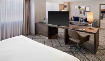 King suite with working station, TV screen and sofa at the DoubleTree by Hilton Tulsa-Downtown.