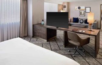 King suite with working station, TV screen and sofa at the DoubleTree by Hilton Tulsa-Downtown.