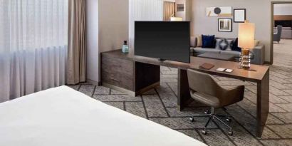 King suite with working station, TV screen and sofa at the DoubleTree by Hilton Tulsa-Downtown.