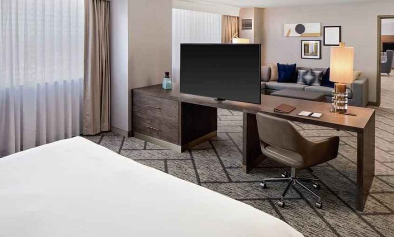 King suite with working station, TV screen and sofa at the DoubleTree by Hilton Tulsa-Downtown.