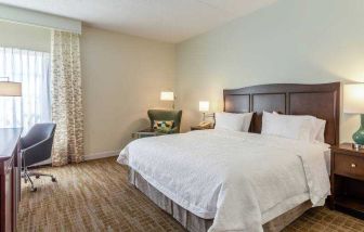 Bright king bedroom with window at the Hampton Inn Boston-Peabody.