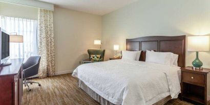 Bright king bedroom with window at the Hampton Inn Boston-Peabody.