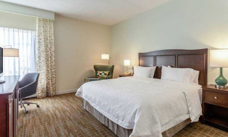 Bright king bedroom with window at the Hampton Inn Boston-Peabody.