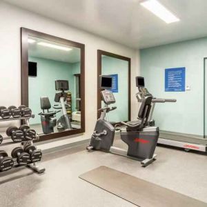 Fitness center with weights and mirrors at the Hampton Inn Boston-Peabody.