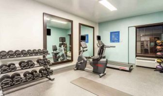 Fitness center with weights and mirrors at the Hampton Inn Boston-Peabody.