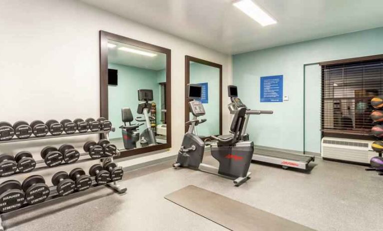 Fitness center with weights and mirrors at the Hampton Inn Boston-Peabody.