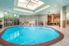 bright-lit indoor pool with sun rooff and comfortable seating area at Embassy Suites by Hilton Seattle Tacoma International Airport.