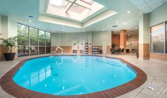 bright-lit indoor pool with sun rooff and comfortable seating area at Embassy Suites by Hilton Seattle Tacoma International Airport.