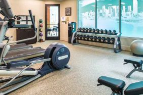 fully equipped fitness center with treadmills and weights at at Embassy Suites by Hilton Seattle Tacoma International Airport.