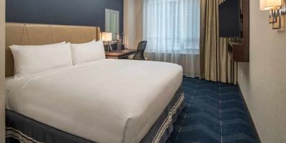 comfortable king room with TV and work desk at Embassy Suites by Hilton Seattle Downtown Pioneer Square.