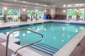 large indoor pool with sunbeds and seating area at Hampton Inn Cranbury.