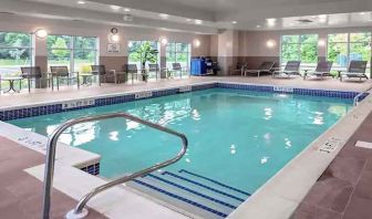 large indoor pool with sunbeds and seating area at Hampton Inn Cranbury.