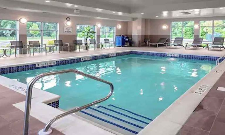 large indoor pool with sunbeds and seating area at Hampton Inn Cranbury.