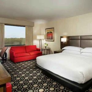 King suite with sofa, TV screen and window at the Hilton Chicago-Northbrook.