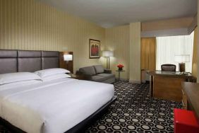 King bedroom with working station and sofa at the Hilton Chicago-Northbrook.