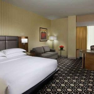 King bedroom with working station and sofa at the Hilton Chicago-Northbrook.