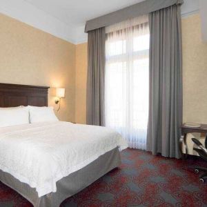 Bright king bedroom with desk and window at the Hampton Inn & Suites Mexico City - Centro Historico.