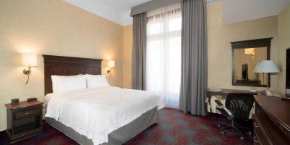 Bright king bedroom with desk and window at the Hampton Inn & Suites Mexico City - Centro Historico.