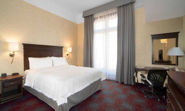 Bright king bedroom with desk and window at the Hampton Inn & Suites Mexico City - Centro Historico.