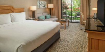 Bright king bedroom with large window overlooking the patio at the DoubleTree by Hilton Sonoma Wine Country.