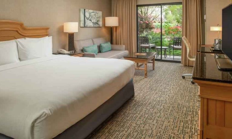 Bright king bedroom with large window overlooking the patio at the DoubleTree by Hilton Sonoma Wine Country.