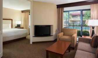 Hotel suite with king size bed, sofa and pool view at the DoubleTree Suites by Hilton Cincinnati-Blue Ash.