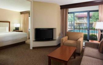 Hotel suite with king size bed, sofa and pool view at the DoubleTree Suites by Hilton Cincinnati-Blue Ash.