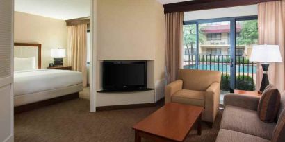 Hotel suite with king size bed, sofa and pool view at the DoubleTree Suites by Hilton Cincinnati-Blue Ash.