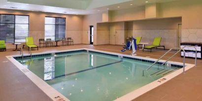 Indoor pool area with lounges and chairs at the Hampton Inn & Suites St. Paul Oakdale/Woodbury by Hilton.