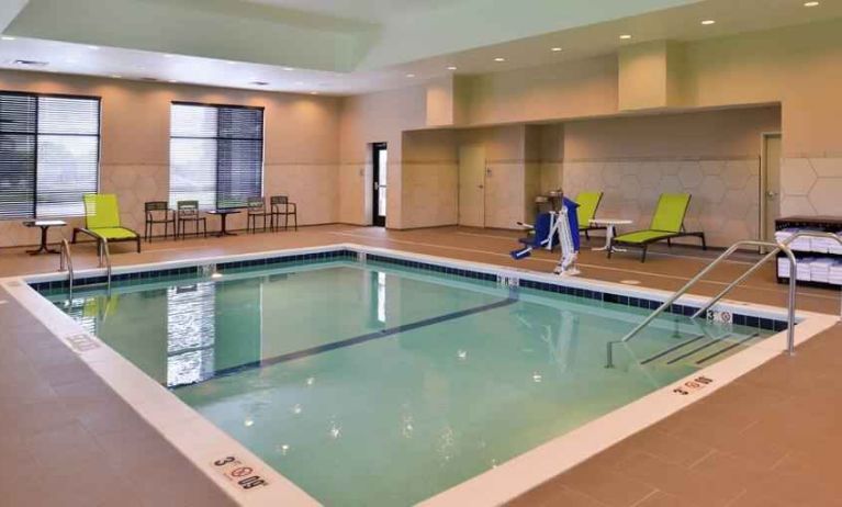 Indoor pool area with lounges and chairs at the Hampton Inn & Suites St. Paul Oakdale/Woodbury by Hilton.