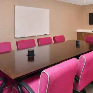 Small meeting room with pink chairs at the Hampton Inn & Suites St. Paul Oakdale/Woodbury by Hilton.