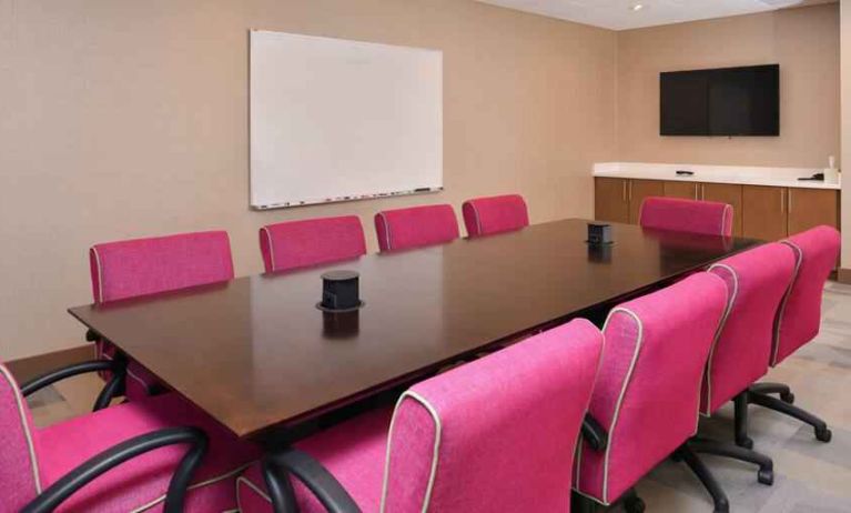 Small meeting room with pink chairs at the Hampton Inn & Suites St. Paul Oakdale/Woodbury by Hilton.