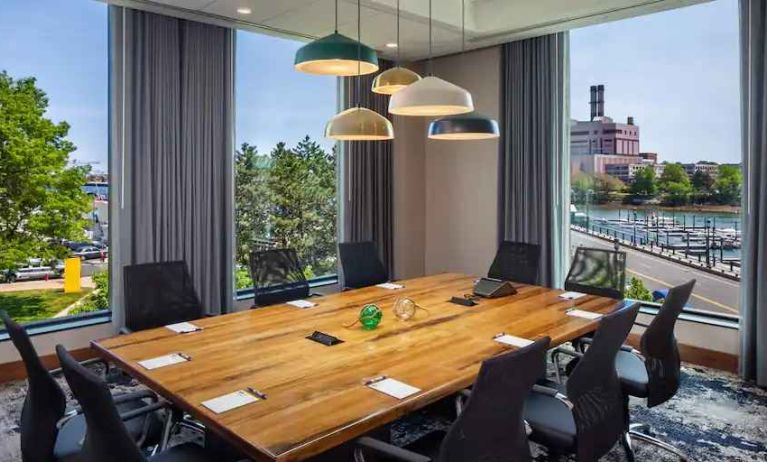 Bright meeting room with windows at the Hampton Inn Boston Seaport District.