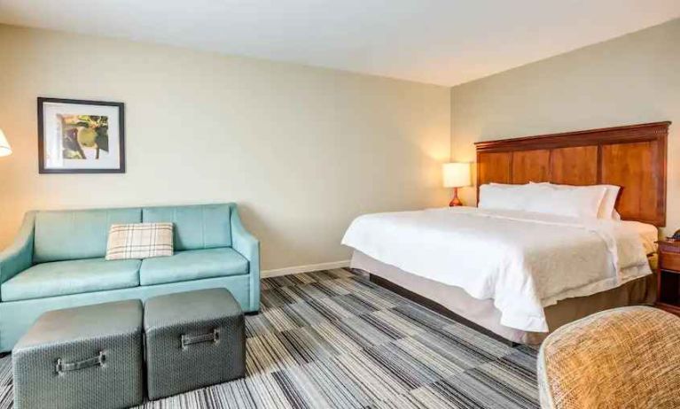 Comfortable king size bed and sofa at the Hampton Inn & Suites Westford-Chelmsford.