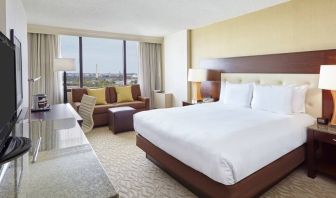 Bright king bedroom with sofa, window and desk at the DoubleTree by Hilton Washington DC - Crystal City.