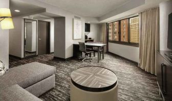 Spacious living room with sofa and working station at the Embassy Suites by Hilton Crystal City National Airport.