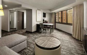 Spacious living room with sofa and working station at the Embassy Suites by Hilton Crystal City National Airport.