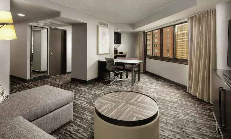 Spacious living room with sofa and working station at the Embassy Suites by Hilton Crystal City National Airport.